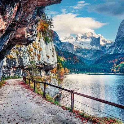 ALIPRINT Chemin de montagne pittoresque au bord d'un lac alpin, entouré de falaises rocheuses, forêt colorée et sommets enneigés. Paysage automnal époustouflant. Algerie