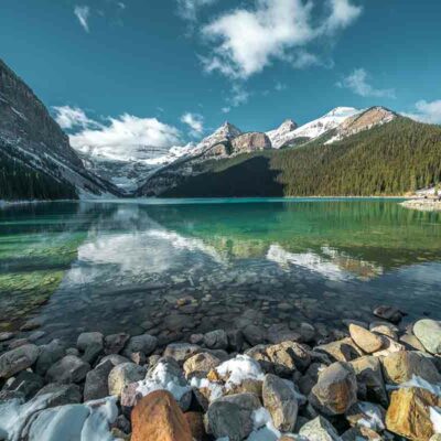 ALIPRINT Lac turquoise entouré de montagnes enneigées et forêt dense, ciel bleu clair avec nuages, paysage naturel idéal pour la photographie de nature. Algerie